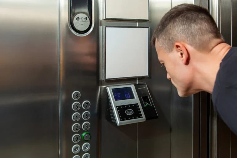 Man using facial recognition security system inside elevator.