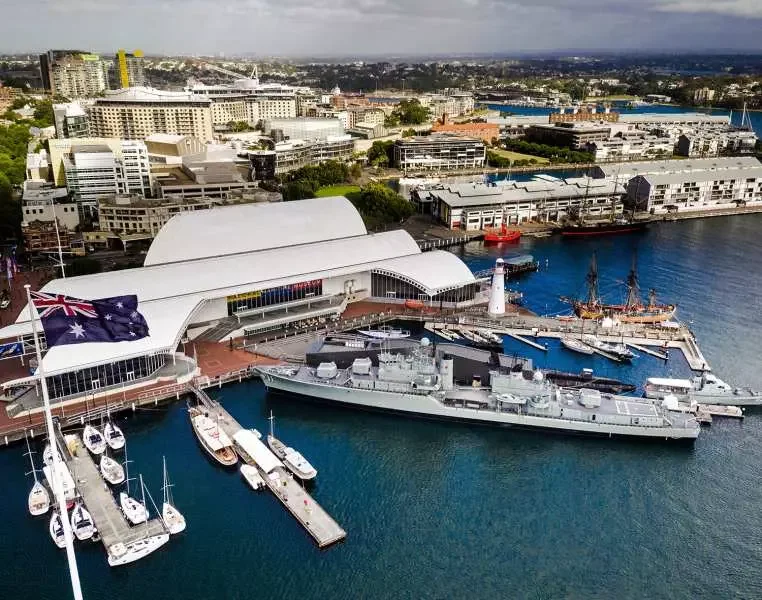 Aerial view of Australian National Maritime Museum with naval ships, lighthouse and marina in Sydney Harbour