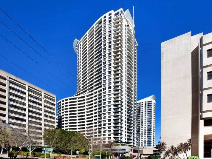 Forum high-rise and mid-rise residential towers in NSW with curved balconies against clear blue sky